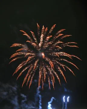 Dramatic orange firework exploding in a black sky Stock Photos