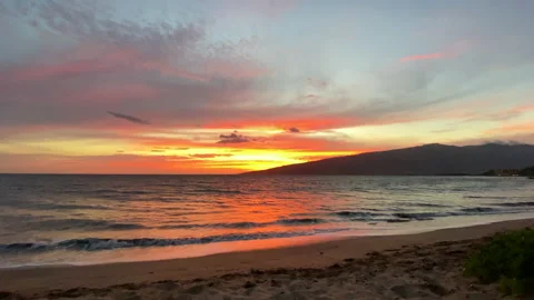 Dramatic orange Hawaii sunset with rolling ocean and small waves in foreground Stock Footage 139545574