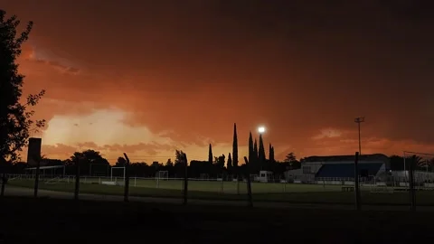 Dramatic orange sky above a sports field at dusk Stock Footage 345619640