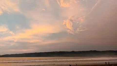Dramatic orange sky reflected on wet beach sand Stock Photos