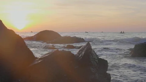 Dramatic orange sunrise over the rocks and the sea in slow motion. Stock Footage 86721646
