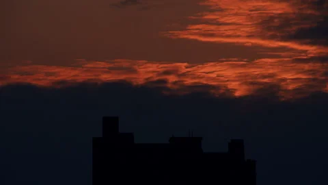 Dramatic Orange Sunset Clouds Over Dark Building Silhouette Stock-Footage 335146720