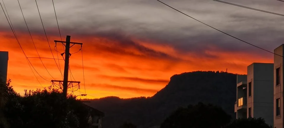 Dramatic Orange Sunset Over Mountain Silhouette Stock Photos