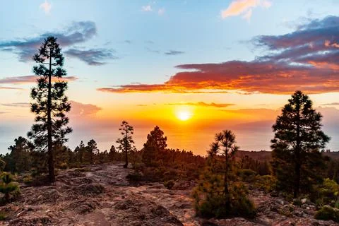 Dramatic orange sunset with scenic clouds in Gran Canaria. Brown desert rocks Fotos de archivo