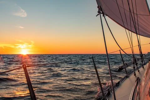Dramatic orange sunset at sea seen from a sailboat Stock Photos