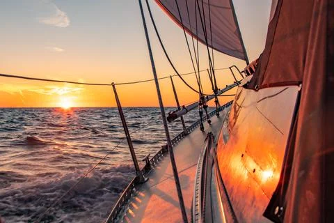 Dramatic orange sunset at sea seen from a sailboat Stock Photos