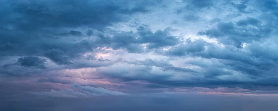 Dramatic overcast sky at evening panoramic shot. Scenic blue gray cloudscape Stock Photos