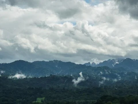 Dramatic Overcast Sky with Heavy Clouds Over Lush Green Tropical Mountains .. Stock Photos