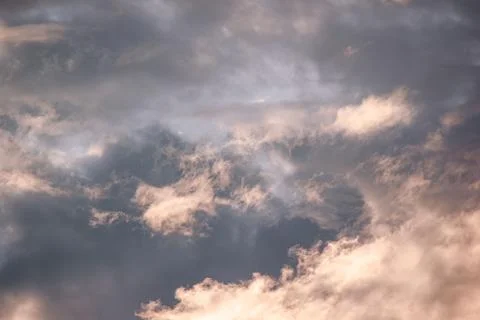 Dramatic overcast sky illuminated by warm sunset golden light background Stock Photos