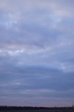 Dramatic overcast sky with layered clouds and subtle pastel hues at dusk ov.. Stock Photos
