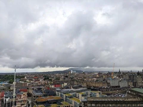 Dramatic overcast sky over the historic and modern roofscape of Edinburgh city Stock Photos