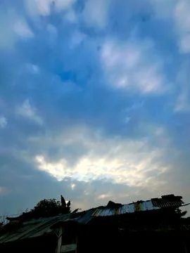 Dramatic Overcast Sky with Soft Golden Sunlight Breaking Through the Dark Clouds Stock Photos