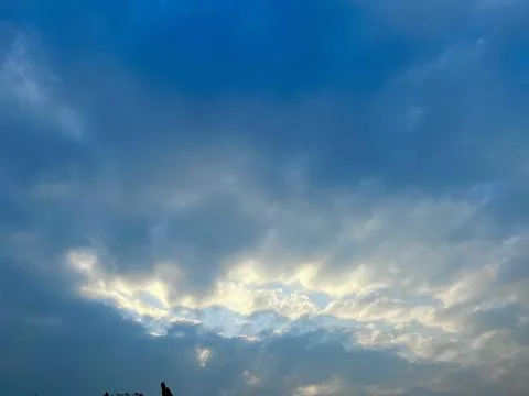 Dramatic Overcast Sky with Soft Golden Sunlight Breaking Through the Dark Clouds Stock-Fotos