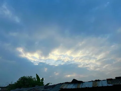 Dramatic Overcast Sky with Soft Golden Sunlight Breaking Through the Dark Clouds Stock Photos