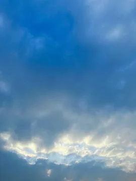 Dramatic Overcast Sky with Soft Golden Sunlight Breaking Through the Dark Clouds Stock Photos