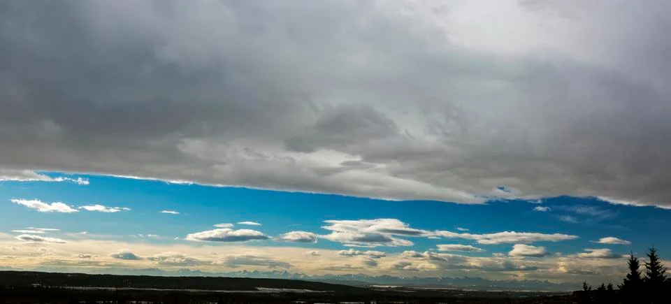 Dramatic panorama chinook arc cloud with blue sky and silhouette mountain range 写真素材