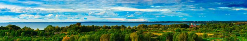 Dramatic panorama of river with right aligned red church Stock Photos