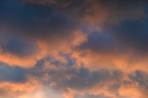 Dramatic pastel sunset clouds in blue evening sky Stock Photos
