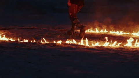 Dramatic performer walking through circle of fire at night Video stock 282964506
