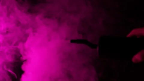 Dramatic pink smoke swirls and drifts across a dark background Stock Footage 340264559