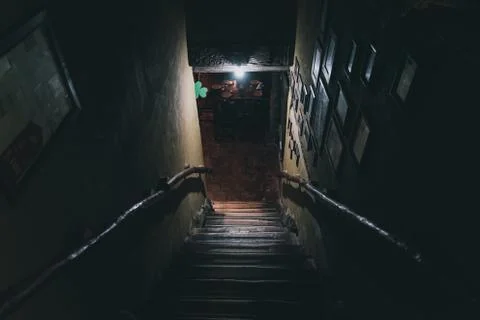 Dramatic point of view of scary stairs from upside into darkness of interior of Stock Photos