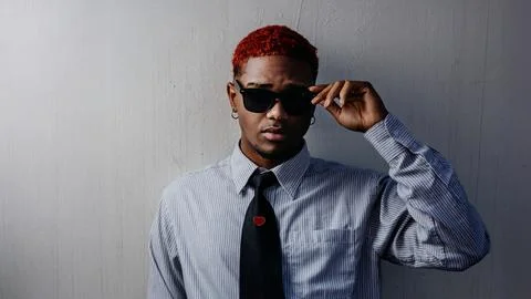 Dramatic portrait of a black guy putting on sunglasses wearing executive dres Stock Photos