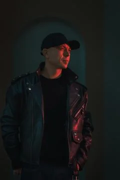 Dramatic Portrait of Man in Black Leather Jacket Under Neon Lights with Cyb.. Stock Photos