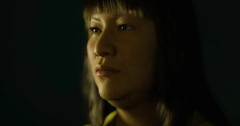 Dramatic portrait of a person in low light with focused expression Illustrazione stock