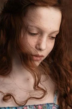 Dramatic portrait of a young cute redhead teenage girl with curly haircut in  Stock Photos