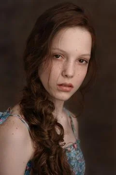 Dramatic portrait of a young cute redhead teenage girl with curly haircut in  Stock Photos