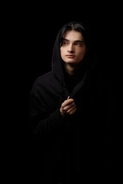 Dramatic portrait of a young man in black clothes on a black background Stock Photos