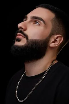A dramatic portrait of a young serious guy, musician, singer, rapper with a b Stock Photos