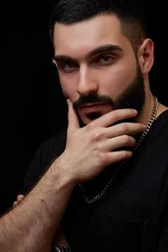 A dramatic portrait of a young serious guy, musician, singer, rapper with a b Stock Photos