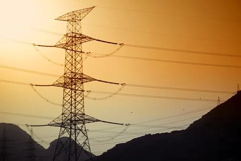 Dramatic power lines against warm gradient sky for infrastructure projects Stock Photos
