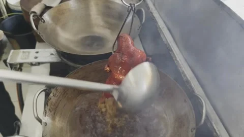 A dramatic process of dousing Peking duck in scalding hot oil from a wok. Stock Footage 297341195