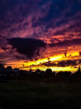 Dramatic purple and orange sunset over rural skyline Photos
