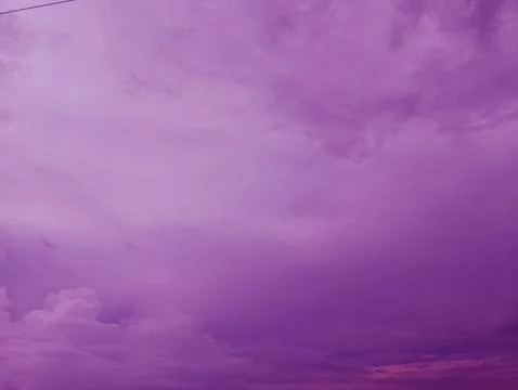 Dramatic purple hued sky filled with soft clouds and unique lighting Stock Photos