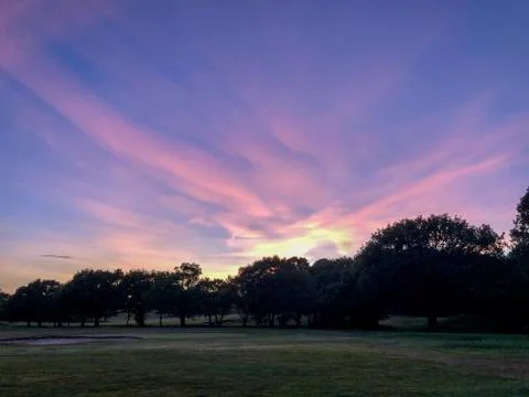 Dramatic purple sunset sky on fields Stock Photos