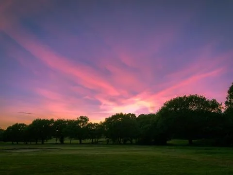 Dramatic purple sunset sky on fields Stock Photos