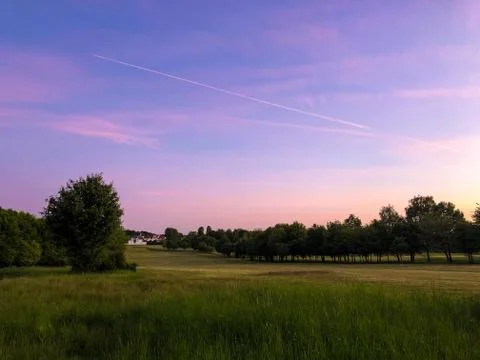 Dramatic purple sunset sky on fields Stock Photos