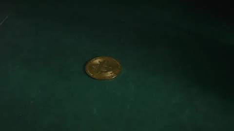 Dramatic push-in ends on lone bitcoin over dark green surface Stock Footage 320926692