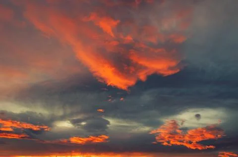 Dramatic radiant fiery orange clouds at sunset Stock Photos