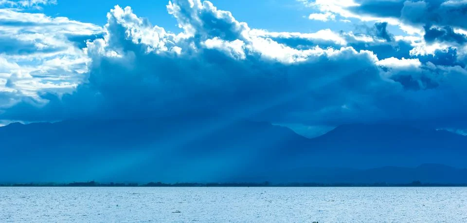 Dramatic rain clouds covers the lake and mountains. Stock Photos