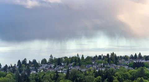 Dramatic Rain Shower Cloud Over Green Suburban Neighborhood Hillside Foto stock