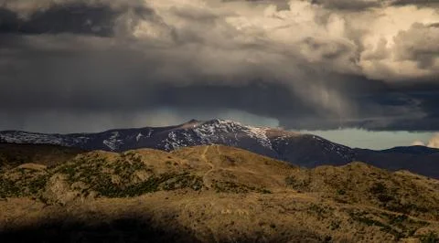 Dramatic rain storm cloud form over the snow mountain in New Zealand Stock Photos