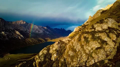 Dramatic Rainbow Over Nianbaoyuze Mountain Range and Lake Qinghai China Stock Footage 346587317