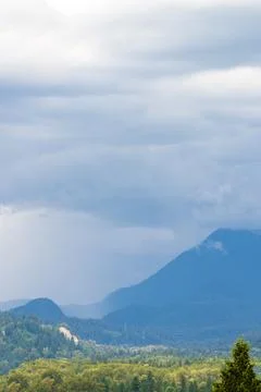 Dramatic Rainfall and Storm Clouds Over Forested Mountains in British Columbi Stockfoto's
