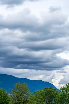 Dramatic Rainfall and Storm Clouds Over Forested Mountains in British Columbi Stockfoto's