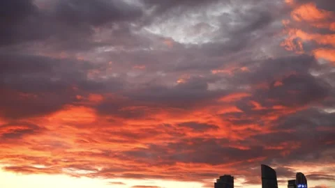 Dramatic red fiery clouds at sunset over city skyline Vidéo 345529140