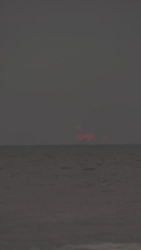 Dramatic red sun disappears below the horizon over the calm sea at dusk 動画素材 342737774